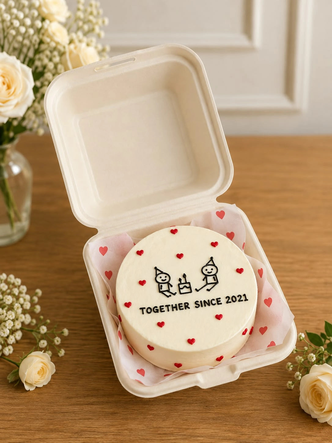 Ivory bento cake featuring illustrated couple doodle, mini cake drawing, and together since milestone text